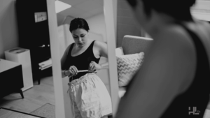 Imagen de mujer midiendo su cintura frente al espejo